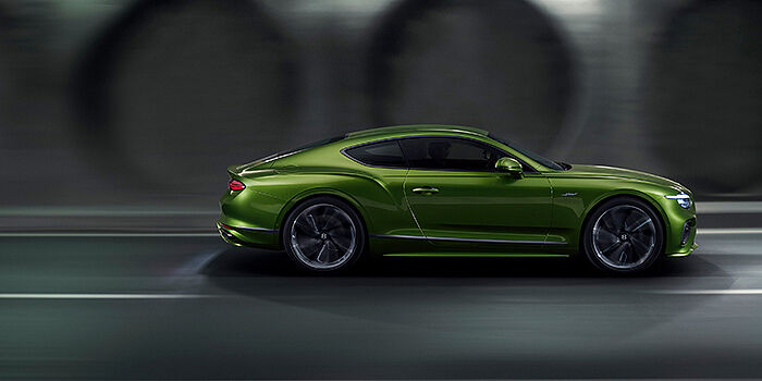  Bentley Baku Bentley Continental GT coupe in Tourmaline Green paint driving in profile on a dark road