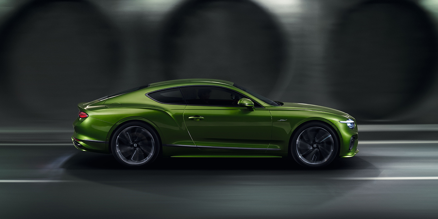 Bentley Baku Bentley Continental GT coupe in Tourmaline Green paint driving in profile on a dark road